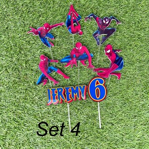 May include: Set of 7 red and blue Spiderman cake toppers with the name Jeremy and the number 6. The toppers are on sticks and are ready to be placed on a cake. Set 4 is written below the toppers.