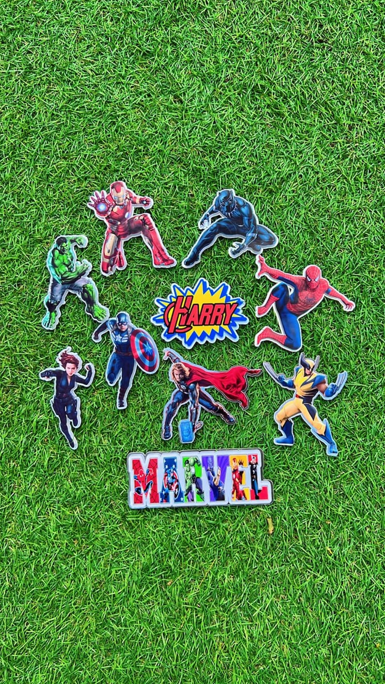 Puede incluir: Una colecci&oacute;n de pegatinas de personajes de superh&eacute;roes Marvel de colores sobre un fondo de hierba verde. Las pegatinas incluyen a Iron Man, Black Panther, Hulk, Capit&aacute;n Am&eacute;rica, Thor, Spider-Man, Wolverine y Black Widow. Tambi&eacute;n se muestra la palabra "Marvel".