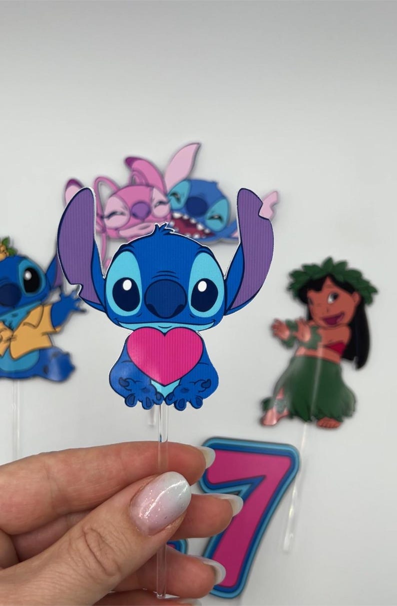 Puede incluir: Un conjunto de cinco adornos para tartas de personajes de dibujos animados azules y rosas con Stitch, Angel y Lilo de la pel&iacute;cula de Disney Lilo & Stitch. Los adornos est&aacute;n en palos de pl&aacute;stico transparentes.