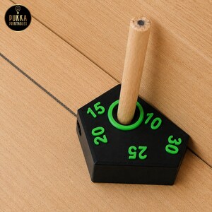 May include: A black, pentagonal pencil sharpener with bright green numbers 10, 15, 20, 25, and 30 embossed on the top surface. A light-coloured wooden pencil is inserted into the central hole. The logo PUKKA PRINTABLES is visible in the corner.