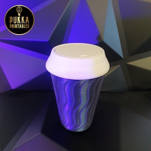 May include: A white travel mug with a wavy pattern and a white lid. The mug is made of plastic and has a black background.