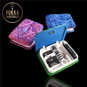 May include: Three biscuit-shaped storage boxes in blue, pink, and purple, with a magnetic clasp. One is open, displaying SD cards and a USB drive. The boxes have a white and green base. The logo "Pukka Printables" is visible in the upper left corner.