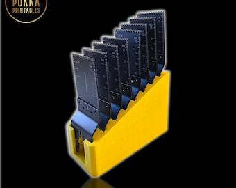 May include: A yellow 8-blade holder with eight black blades. The blades are arranged in a row and have measurement markings. The text "8-Blade Holder" is at the top, and "Mounts on Wall or Bench" is at the bottom.