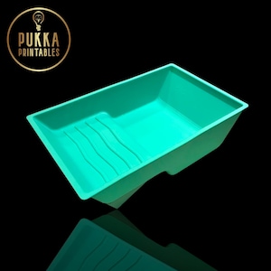 May include: A teal paint tray with a rectangular design and a built-in paint roller grid. The tray is made of plastic and has a handle on one side. The logo "Pukka Printables" is in a gold circle in the upper left corner.