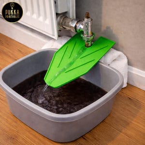 Peut inclure: Un outil de vidange de radiateur vert en forme de feuille dirige l'eau d'une vanne de radiateur vers une bassine grise. L'eau est sombre. L'image contient le texte "Pukka Printables".