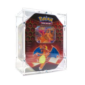 May include: A clear acrylic display case containing a red and orange Pokémon Trading Card Game Charizard GX metal tin. The tin features a graphic of the Charizard character, a honeycomb pattern, and the Pokémon Trading Card Game logo text.