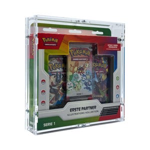 Puede incluir: Una vitrina transparente de acrílico que contiene paquetes de cartas coleccionables de Pokémon. Los paquetes presentan ilustraciones coloridas y el texto "Pokémon" y "Serie 1". La vitrina también tiene el texto "ERSTE PARTNER ILLUSTRATIONS-KOLLEKTION".