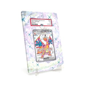May include: A graded Charizard trading card in a clear acrylic display case. The card features a colorful illustration of a dragon. The case has a holographic background with a red and white label.