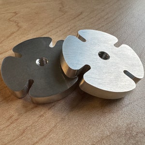 May include: Two metal, star-shaped, decorative pieces. One is silver and the other is a darker gray.