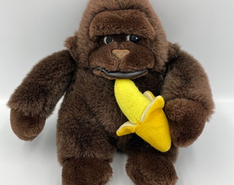 Rétro des années 1980 tenant une peluche singe gorille banane avec étiquette. En excellent état avec des yeux de dessin animé. Peluche marron, excellent cadeau