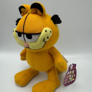 Peluche retrò a forma di gatto Garfield da 19 cm con etichetta originale in carta per altalena di Play By Play/Paws, tratto dalla serie TV anni '80. Con etichetta, in ottime condizioni.