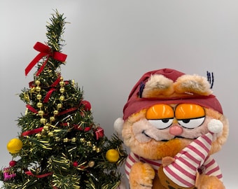 Świąteczna piżama z kotem Garfieldem trzymającym w ręku pluszową zabawkę Pooky Vintage Retro wyprodukowaną przez Dakin na podstawie programu telewizyjnego z lat 80. z lat 1978-1981, United Feature Syndicate