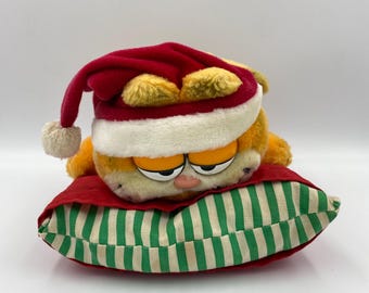 Christmas Garfield Cat Vintage Retro Soft Plush Toy laying on Pillow made by Dakin from 1980s TV Show 1978-1981, United Feature Syndicate