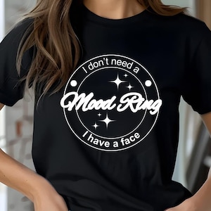 May include: Black t-shirt with a white circle graphic that says "I don't need a Mood Ring I have a face".