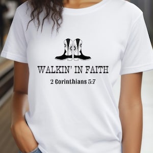 May include: White t-shirt with a black graphic of two cowboy boots and the text "Walkin' in Faith" with the scripture reference "2 Corinthians 5:7".