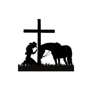 May include: Silhouette of a woman kneeling in prayer with a horse beside her, both facing a wooden cross.