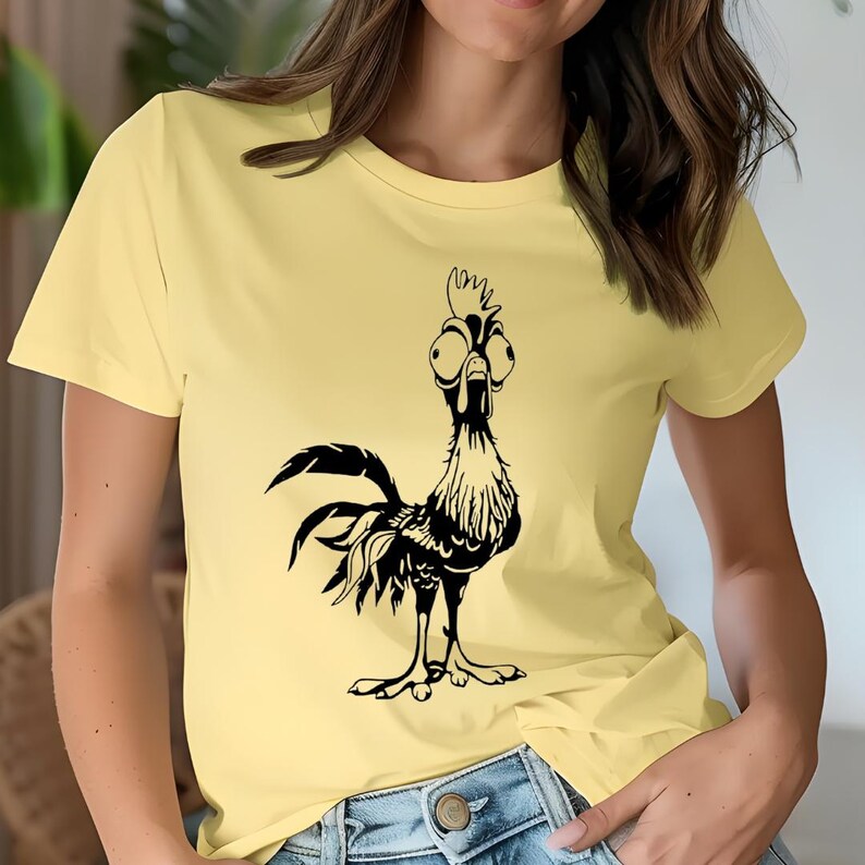 May include: A yellow t-shirt with a black cartoon rooster with large eyes. The rooster is looking to the right.