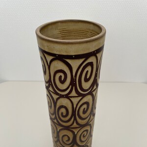 Op de afbeelding: Een keramische vaas met een bruin en beige swirl-patroon.