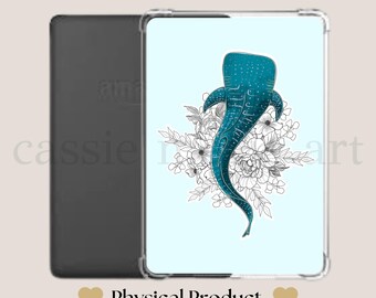 Könnte beinhalten: Kindle Clear Case Einsatz. Ein klarer Case-Einsatz mit einem Design eines türkisblauen Walhais mit weißen floralen Akzenten auf hellblauem Hintergrund. Der Einsatz wird neben einem schwarzen Kindle-Gerät gezeigt. Der Text "Physical Product" wird angezeigt.