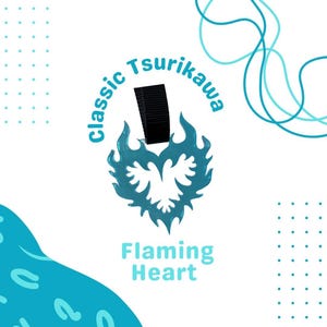 Puede incluir: Un amuleto de corazón azul turquesa con un diseño de llama y una correa negra. El amuleto tiene el texto "Classic Tsurikawa" alrededor de la parte superior y "Flaming Heart" debajo del amuleto.