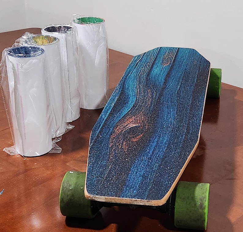 May include: A blue and brown electric skateboard with green wheels. The skateboard has a wood grain pattern on the deck.