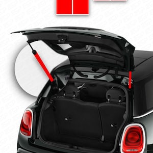 Könnte beinhalten: Ein schwarzer Mini Cooper Kombi mit offenem Kofferraum, der den Innenraum des Laderaums zeigt. Der Kofferraum wird von einer roten Gasdruckfeder offen gehalten.