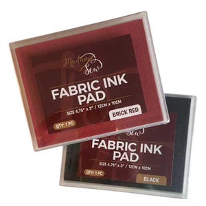 May include: Two fabric ink pads in clear plastic cases. One is brick red, the other black. Each pad is labeled "FABRIC INK PAD" with the size 4.75" x 3" / 12cm x 10cm. The brick red pad is labeled "BRICK RED" and the black pad is labeled "BLACK".