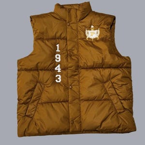 May include: A brown puffer vest with a white embroidered logo and the numbers 1943 on the front.