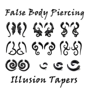 Puede incluir: Un conjunto de pendientes falsos para el cuerpo de color negro, también conocidos como tapers de ilusión, con varios diseños. Los pendientes están hechos de un material plástico duro y están diseñados para parecer piercings reales.