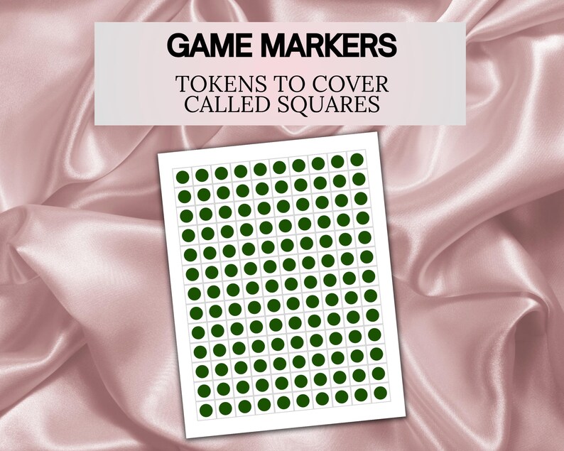 May include: A sheet of game markers with green circular tokens to cover called squares. The text "GAME MARKERS" and "TOKENS TO COVER CALLED SQUARES" is displayed on a white rectangle above the sheet. The background is a pink satin fabric.