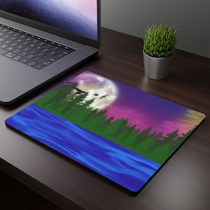May include: A rectangular mousepad featuring a landscape painting. The design includes a blue river, green trees, a large moon, and a purple and pink sky. Silhouetted birds fly across the moon. The mousepad is on a dark wooden desk next to a laptop and a small potted plant.