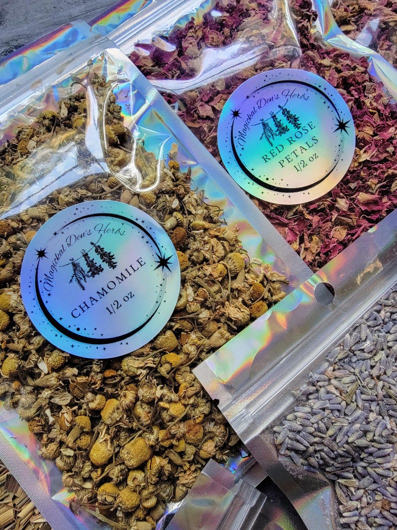 May include: Three resealable bags of dried herbs, each with a holographic label. The labels feature a whimsical tree design and the names of the herbs: Chamomile, Red Rose Petals, and Lavender. Each bag contains 1/2 ounce of herbs.