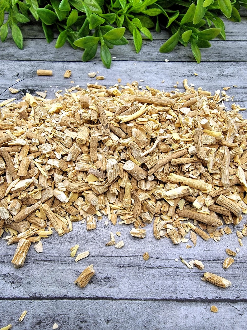 May include: A close-up of a pile of dried, light brown, and beige root pieces. The root pieces are broken into various sizes and shapes. The root pieces are on a light gray wooden surface.