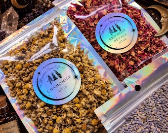 May include: Three holographic pouches containing dried herbs. One pouch holds yellow chamomile flowers, one holds red rose petals, and one holds purple lavender buds. Each pouch features a circular label with the text Magickal Dews Herbs.