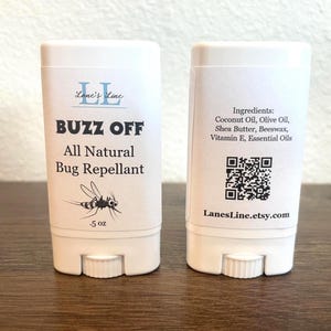 May include: White tube with a black label that says "Lane's Line" and "Buzz Off All Natural Bug Repellant". The label also has a cartoon mosquito and says ".5 oz". The back of the tube has a list of ingredients, a QR code, and the website "LanesLine.etsy.com".