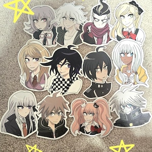 Op de afbeelding: Een set van 11 kleurrijke anime-personage stickers. De stickers tonen personages met verschillende kapsels, kleding en uitdrukkingen. De stickers zijn gedrukt op wit papier en hebben een glanzende afwerking.