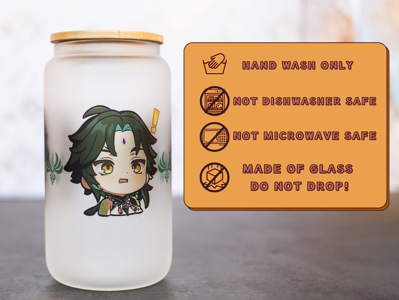 Peut inclure: Un pot en verre givr&eacute; avec un couvercle en bambou repr&eacute;sentant un personnage de dessin anim&eacute; aux cheveux verts et une expression surprise. Le pot porte une &eacute;tiquette d'avertissement indiquant "LAVAGE &Agrave; LA MAIN UNIQUEMENT", "NE PAS LAVER AU LAVE-VAISSELLE", "NE PAS METTRE AU FOUR &Agrave; MICRO-ONDES", "FAIT EN VERRE NE PAS LAISSER TOMBER !"