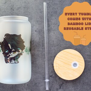 Peut inclure: Un gobelet blanc givr&eacute; avec un motif de personnage d'anime vert et noir. Le gobelet est livr&eacute; avec un couvercle en bambou et une paille r&eacute;utilisable. "Every tumbler comes with a bamboo lid & reusable straw" est &eacute;crit sur un cercle beige.