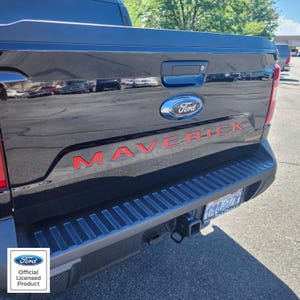 May include: Black Ford Maverick truck tailgate with red "MAVERICK" lettering and a blue Ford emblem. The truck has a black bumper and a trailer hitch. The image includes the "Ford Official Licensed Product" logo.