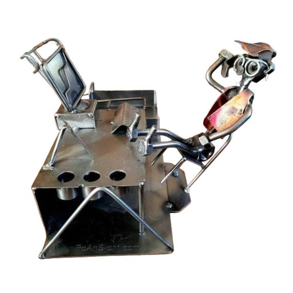 A quirky, handcrafted metal desk tidy with collectible novelty character — the kind of one-off piece that makes a desk feel like a personality, not just a workspace.