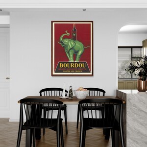 以下が含まれることがあります： フランスのキニーナ・アペリティフ、ブルドゥーのヴィンテージ広告ポスター。ポスターには、ブルドゥーのボトルを背中に乗せた緑色の象が後ろ足で立っている様子が描かれている。ポスターのテキストには、「ブルドゥー グラン キニーナ アペリティフ コントレ レ フィエーブル」と書かれている。