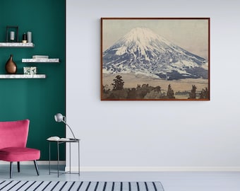 May include: A framed print of a mountain landscape with a snowy peak. The mountain is depicted in shades of blue and white, with a brown foreground and a light blue sky.