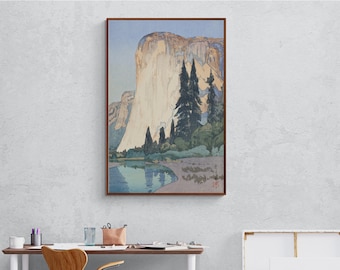 May include: A woodblock print of a mountain range with a river in the foreground. The mountain is a light brown color with a white peak. The river is a light blue color and reflects the mountain. There are trees in the foreground.