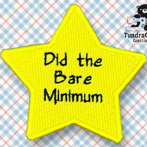 Pode incluir: Etiqueta amarela em forma de estrela com texto bordado em preto que diz "Did the Bare Minimum".