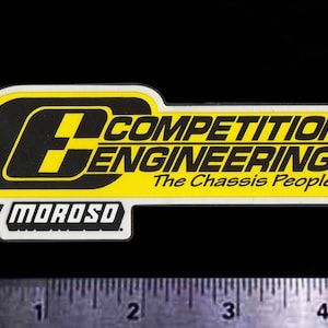 May include: Yellow and black sticker with the text "Competition Engineering The Chassis People" and "by Moroso" in a white border.