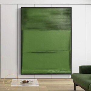 Puede incluir: Pintura abstracta con fondo verde y pinceladas horizontales. La pintura est&aacute; enmarcada en negro y cuelga de una pared blanca.