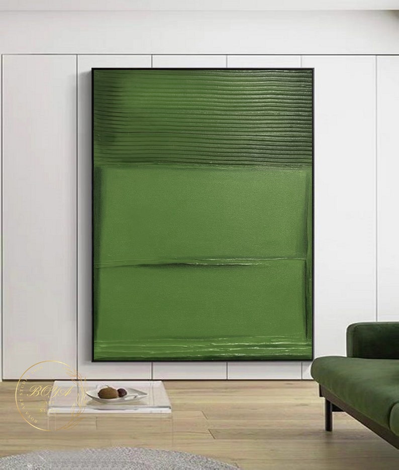 Puede incluir: Pintura abstracta con fondo verde y pinceladas horizontales. La pintura est&aacute; enmarcada en negro y cuelga de una pared blanca.