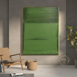 Puede incluir: Pintura abstracta con fondo verde y l&iacute;neas horizontales. La pintura est&aacute; enmarcada en oro y cuelga de una pared gris.