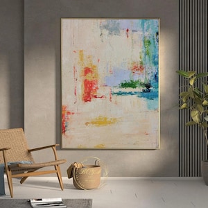 Peut inclure: Peinture abstraite sur fond blanc avec des coups de pinceau color&eacute;s dans des tons de rouge, jaune, bleu et vert. La peinture est encadr&eacute;e dans un cadre dor&eacute;.