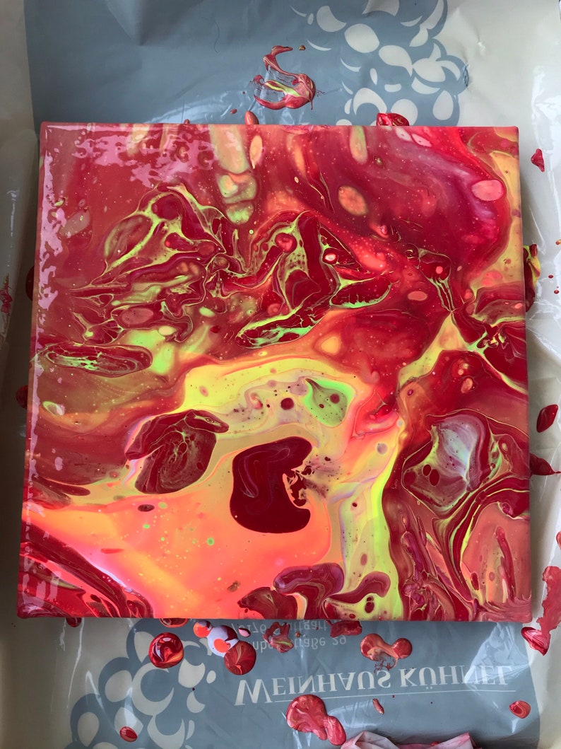 May include: Square abstract art piece with a vibrant mix of red, yellow, and green hues. The fluid design features swirling patterns and color gradients, creating a dynamic and eye-catching visual effect. The artwork is on a square canvas.